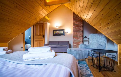 a attic room with a bed and a couch at Etiuda Zakopane in Zakopane