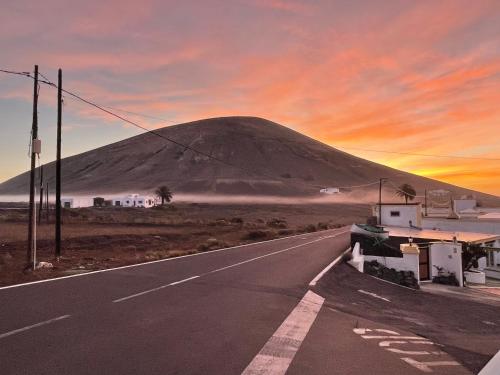 a road in the desert with a mountain in the background at HOTELITO RURAL GA7COLORES only adult in Montaña Blanca