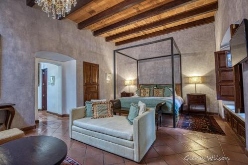 a living room with a bed and a couch at San Rafael Hotel in Antigua Guatemala