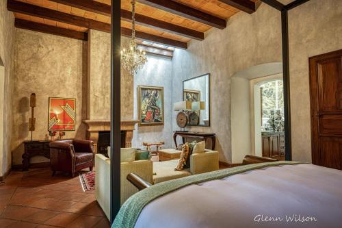 a bedroom with a bed and a living room at San Rafael Hotel in Antigua Guatemala