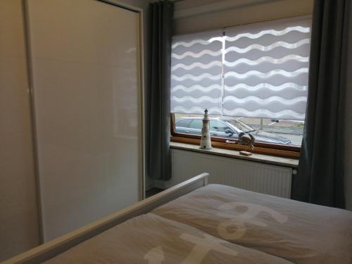 ein Schlafzimmer mit einem Fenster mit Blick auf ein Auto in der Unterkunft Steinmarner Bude 3 in Cuxhaven