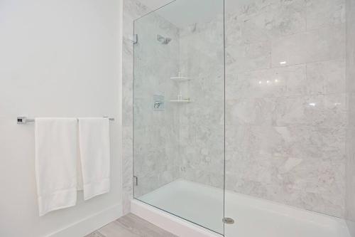 a bathroom with a shower with a glass door at Harbourtown Suites on Plymouth Harbor in Plymouth