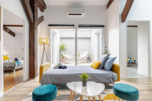 une chambre avec un lit, une table et des chaises dans l'établissement Aux portes de Bordeaux Le Patio Samba MindUrGuest, à Bègles