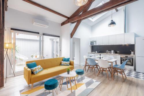 un salon avec un canapé jaune et une table dans l'établissement Aux portes de Bordeaux Le Patio Samba MindUrGuest, à Bègles