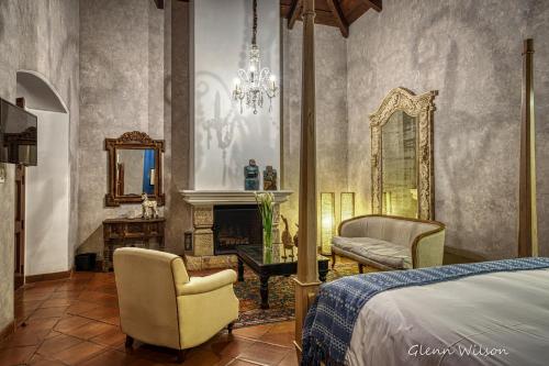 a bedroom with a bed and a chair and a mirror at San Rafael Hotel in Antigua Guatemala