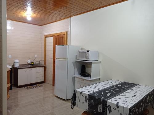 a kitchen with a white refrigerator and a microwave at A Casa é Sua! in Urubici
