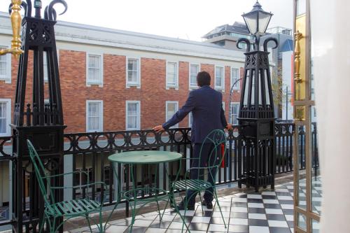 a man standing on a fence on a balcony at VR Hamilton in Hamilton