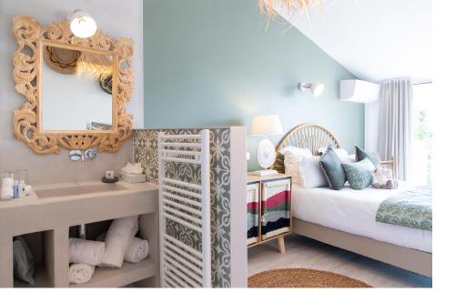 a bedroom with a bed and a sink and a mirror at Hôtel Font Mourier in Cogolin