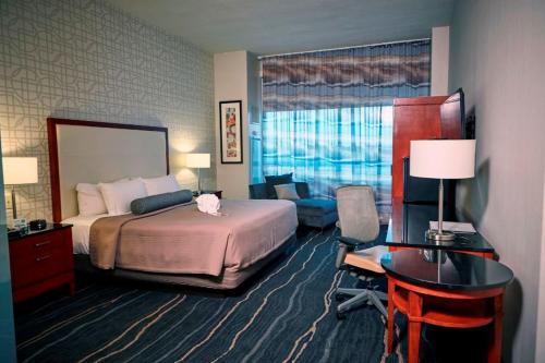 a hotel room with a bedroom with a bed and a desk at Bally's Quad Cities Casino & Hotel in Rock Island