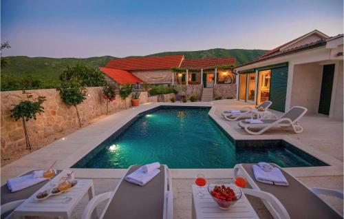 a swimming pool with chairs and a house at Gorgeous Home In Slivno With Sauna in Slivno