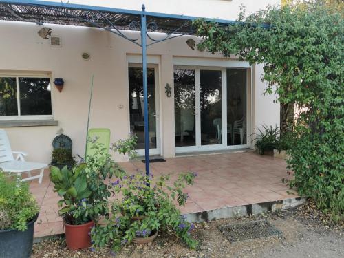 a patio outside of a house with plants at Un coin de campagne à 4km de la mer pour 4 à 6 personnes in Portiragnes