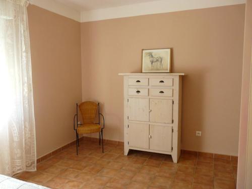 a bedroom with a white dresser and a chair at Un coin de campagne à 4km de la mer pour 4 à 6 personnes in Portiragnes
