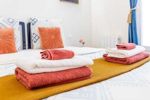 2 piles de serviettes assises au-dessus d'un lit dans l'établissement StayLib - Chic and Cosy 2 rooms porte de Montmartre, à Saint-Ouen