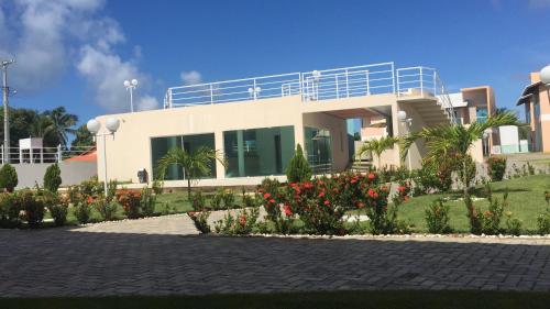 una casa con muchas flores delante de ella en vilage em guarajuba bahia, en Salvador