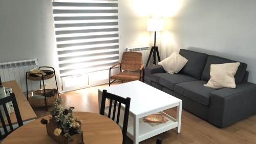 薩拉曼卡的住宿－VuT BALBOA APARTAMENTO，客厅配有沙发和桌子