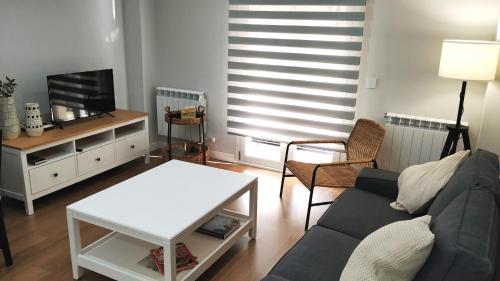 sala de estar con sofá y TV en VuT BALBOA APARTAMENTO en Salamanca