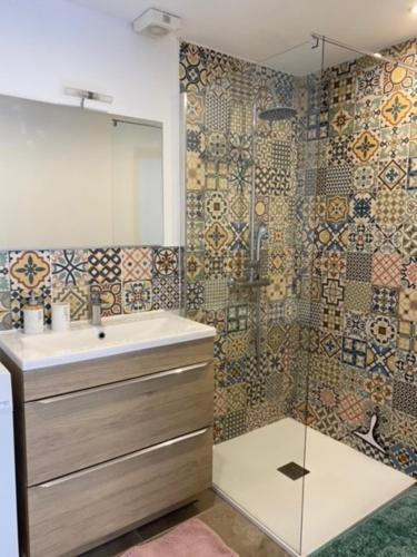 uma casa de banho com um lavatório e um espelho em Le Clos Bellevue em Tressan