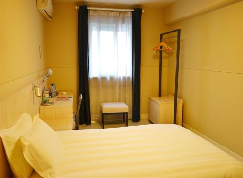 a bedroom with a bed and a desk and a window at Jinjiang Inn - Suzhou Wuzhong Baodai West Road in Suzhou