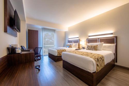 a hotel room with two beds and a television at Sleep Inn Guadalajara Galerias in Guadalajara