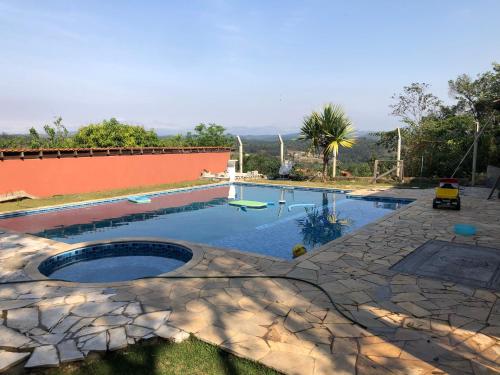 uma piscina num quintal com um pátio de pedra em Chácara Belo Horizonte em Mairinque