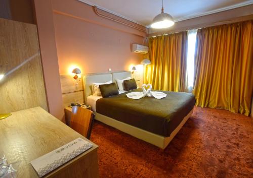 a hotel room with a bed with a bow on it at John's Hotel in Chalkida