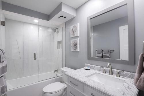 Un baño con inodoro, lavabo y ducha. en Beachfront condo with heated pool, gym and pickleball, en Marco Island