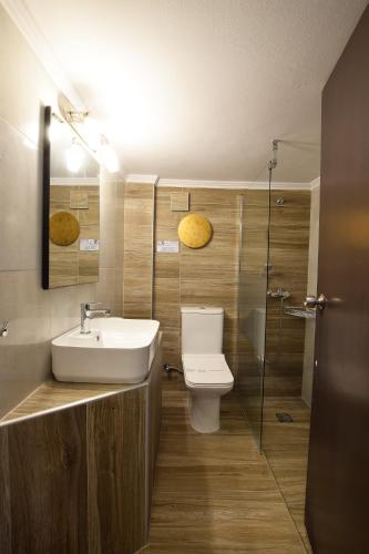 a bathroom with a sink and a toilet and a shower at John's Hotel in Chalkida