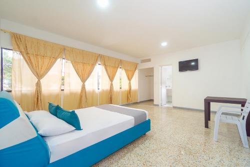 1 dormitorio con cama, mesa y TV en Ayenda Hotel Paraiso Chipichape, en Cali