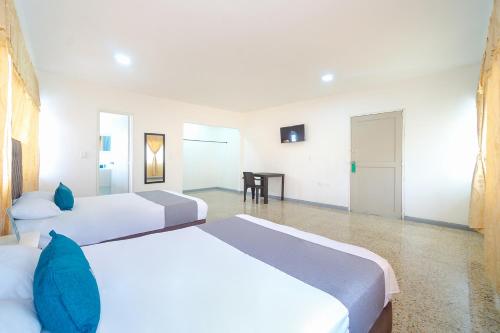 カリにあるAyenda Hotel Paraiso Chipichapeのベッド2台とテーブルが置かれた寝室