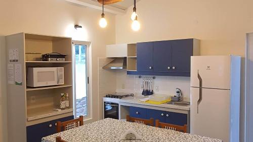 a kitchen with blue cabinets and a white refrigerator at Vista Alegre Natural Resort - Villas & Cabañas in Independencia