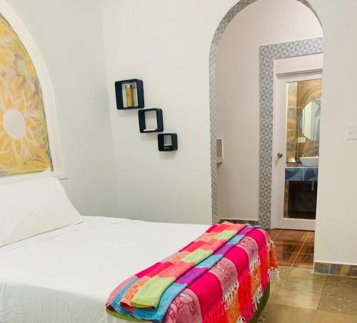 a bedroom with a bed with a colorful blanket on it at The Quetzal in Cancún