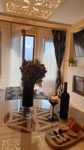 a table with a plate of bread and a bottle of wine at Villa Fortuna - Regionalne apartamenty & SPA - Sauna, Grill, Jacuzzi z widokiem na Tatry in Zakopane