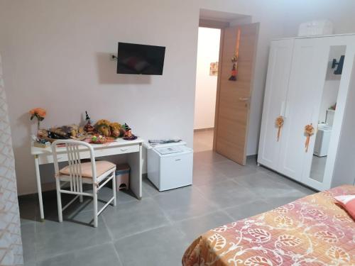 Zimmer mit einem Schreibtisch, einem Tisch und einer Küche in der Unterkunft B&B Petra Hercules in Torre Annunziata