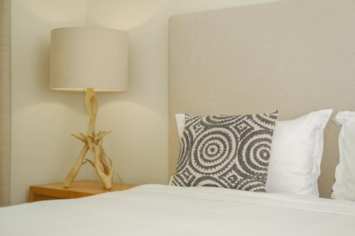 a bedroom with a bed with a lamp and a pillow at Sandalwood in Avoca Beach