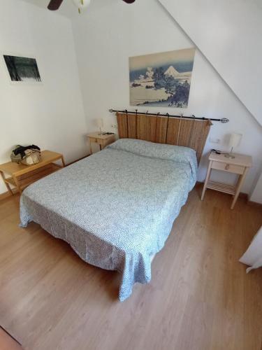 um quarto com uma cama com uma cabeceira de madeira em Apartamento en Monachil pueblo em Monachil