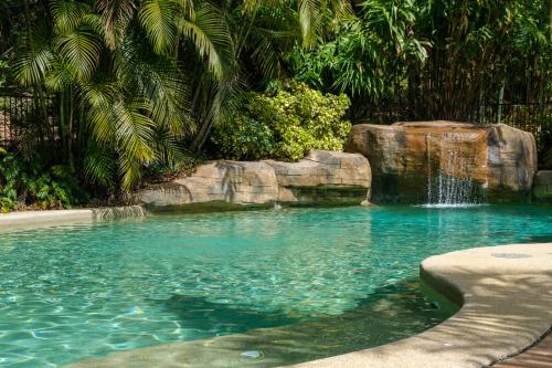 a swimming pool with a waterfall in a yard at Sandalwood in Avoca Beach