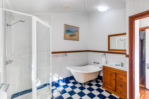 a bathroom with a tub and a sink at Island Adventure Holiday House in Picnic Bay