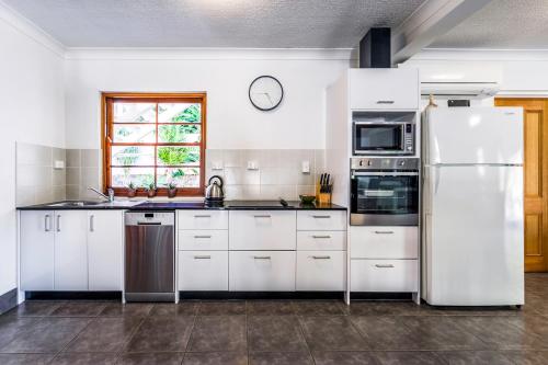 a kitchen with white appliances and a window at Island Adventure Holiday House in Picnic Bay