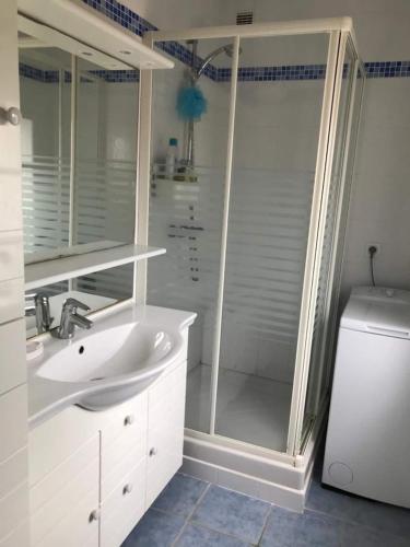 une salle de bain blanche avec une douche et un lavabo dans l'établissement St Mart. l'îlot Rhéa, à Saint-Martin-de-Ré