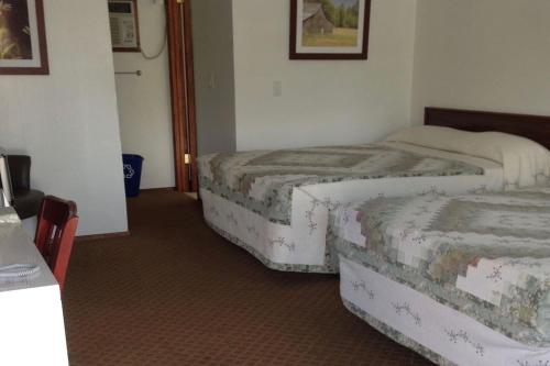 una camera d'albergo con due letti e un tavolo di Dutch Cup Motel a Sultan