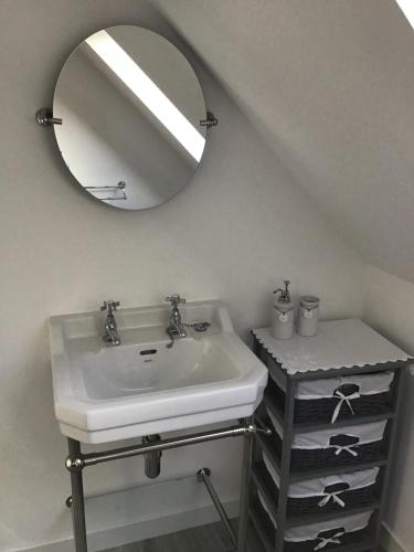 a bathroom with a white sink and a mirror at Belforte House Holiday Home in Inverness