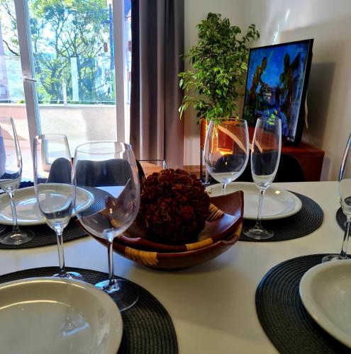 a table with wine glasses and a bowl of food at Loft Gramado in Gramado