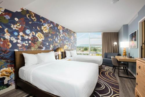 a hotel room with two beds and a desk at Versante Hotel in Richmond