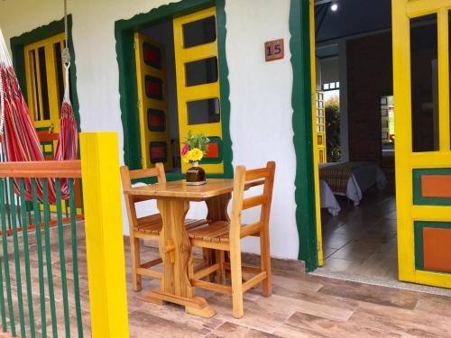 einen Holztisch und Stühle vor einem Haus in der Unterkunft Mamatina Hotel in Santa Rosa de Cabal
