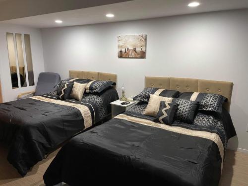 a bedroom with two beds with black comforters at motel Christine in Lac-Bouchette