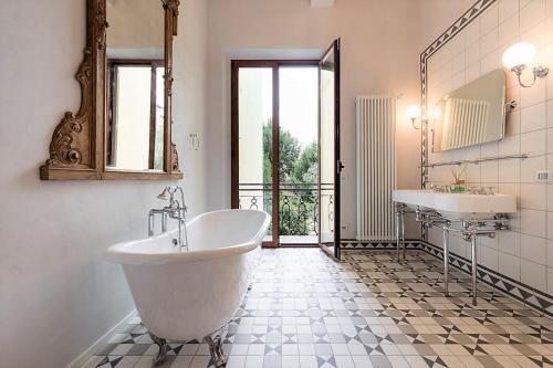 La salle de bains est pourvue d'une baignoire, d'un lavabo et d'un miroir. dans l'établissement Borgo Pinti Suites Le Stanze dei Nobili, à Florence