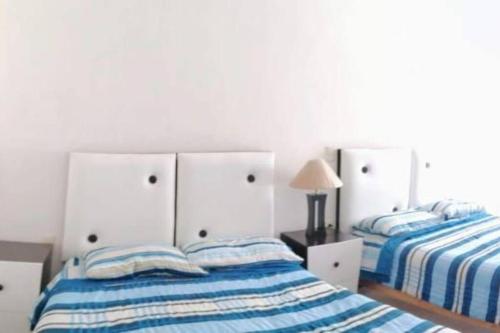 um quarto com 2 camas com lençóis azuis e brancos em Departamento en condominio Diamante Turquesa em Acapulco