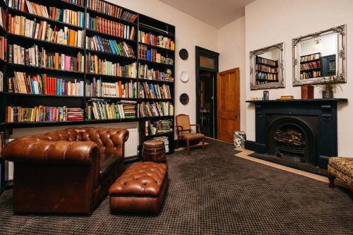 a living room with a leather couch and a fireplace at Hotel Etico at Mount Victoria Manor in Mount Victoria