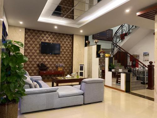 a living room with a couch and a tv and stairs at Hotel Mỹ Mỹ in Tây Ninh
