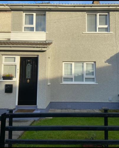 a house with a black door and a bench in front of it at Wayside in Tandragee